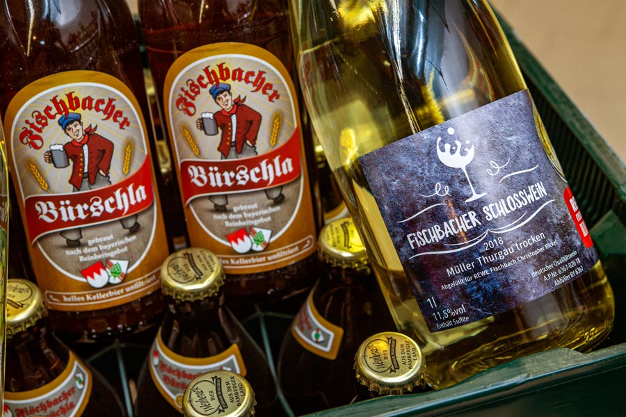 Bierkasten gefüllt mit Fischbacher Bürschla und einer Flasche Fischbacher Schlosswein